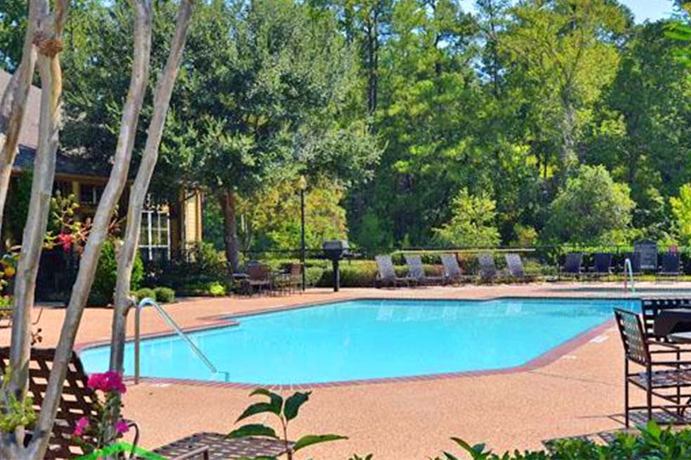 Sparkling swimming pool with tanning deck at the Arbors of Sam Houston